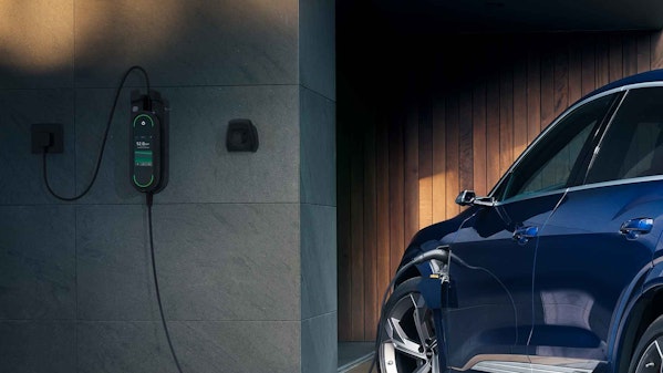Blauer Audi e-tron wird an einer Wallbox in einer stilvollen Hausgarage geladen – Elektromobilität für nachhaltiges Fahren im Alltag.