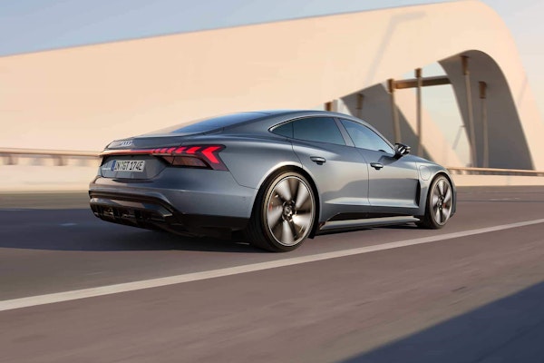 Audi e-tron GT in Bewegung auf einer modernen Brücke – Dynamisches Elektrofahrzeug mit sportlichem Design und markanter Heckpartie.