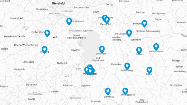 Karte mit Standorten von Ladestationen für Elektrofahrzeuge in der Region Paderborn, Detmold und Umgebung, markiert durch blaue Icons mit Ladesymbol.