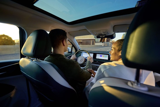 Innenraum eines GWM ORA Funky Cat – Ein Fahrer und eine Beifahrerin genießen die Fahrt bei Sonnenuntergang mit modernem Infotainment-System.