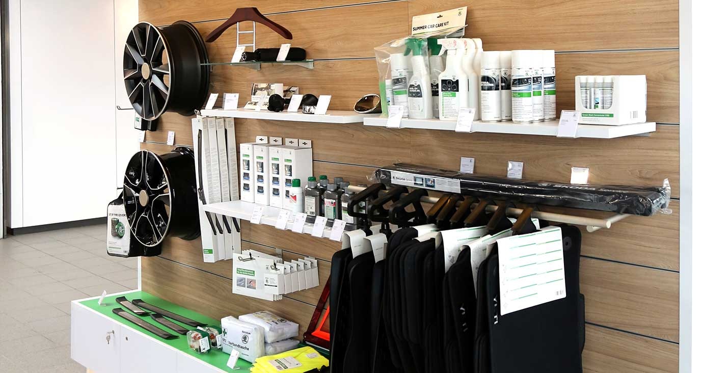 Zubehör- und Pflegemittelbereich im Autohaus Thiel in Schloß Neuhaus – Präsentation von Škoda-Felgen, Autopflegeprodukten, Fußmatten, Kleiderbügeln und weiteren Originalzubehörartikeln.